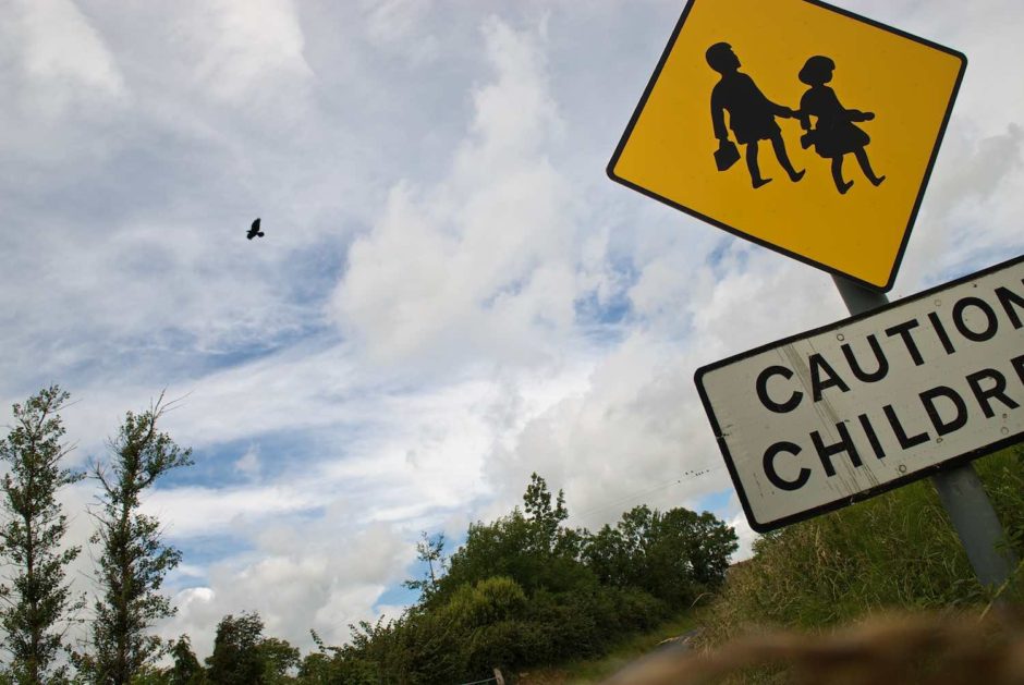 Kleurfoto van een verkeersbord dat waarschuwt voor overtekende kinderen